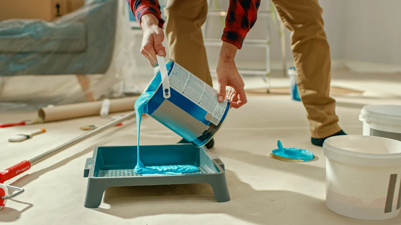 Painter pouring paint for roller
